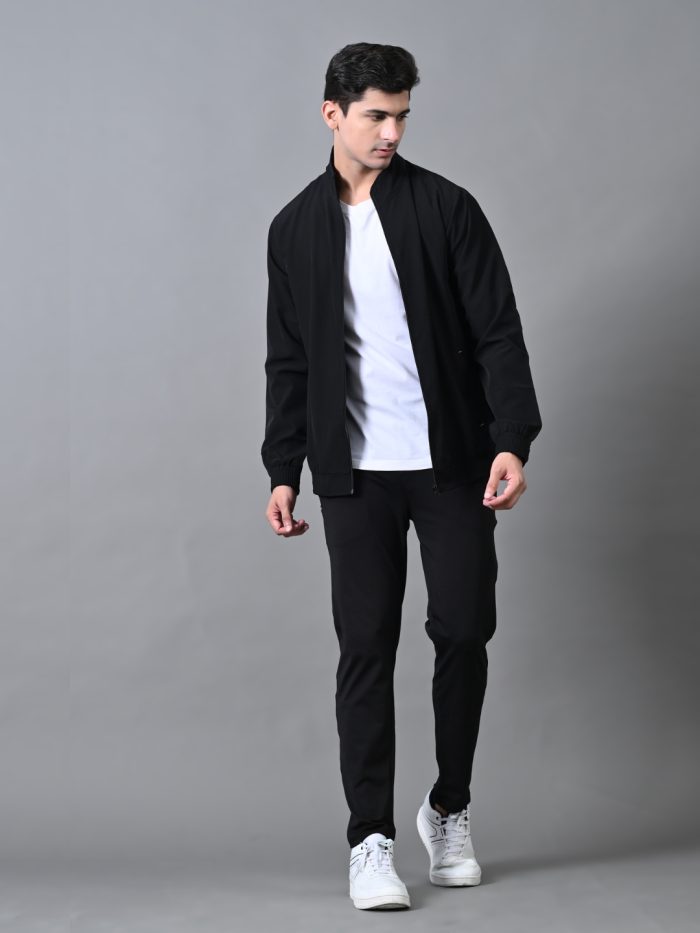 A man wearing a black winter tracksuit with a jacket and joggers